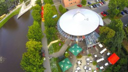 Vogelperspektive auf ein großes, modernes Kulturzentrum direkt neben einem Fluss.